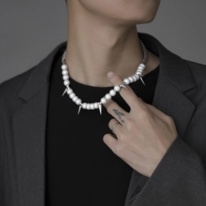 Detail of hip-hop pearl necklace with silver metal spikes for a street style look