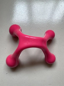 Detailed top view of the pink plastic four-point massager with ergonomic roller heads