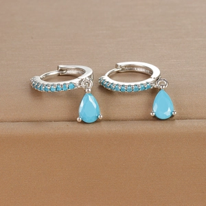 Macro detail of sky blue teardrop earrings with silver finish and crystal pave setting