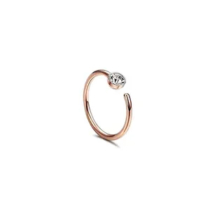 Detail of rose gold C-shaped nose ring featuring a sparkling round zircon crystal
