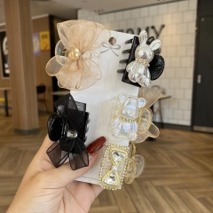 Close-up of hair accessory set with tulle bows, pearls and crystal bear charms