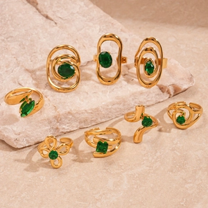 Gold stainless steel oval green zircon swirl rings displayed on elegant stone surface