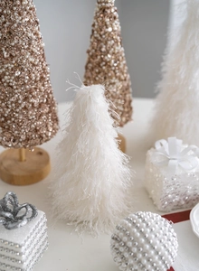 Detail of mini white feather and rose gold sequin Christmas trees with elegant gift box