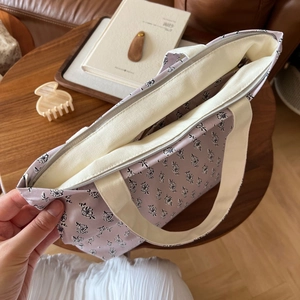 Detailansicht der kleinen Stofftasche mit Blumenmuster, cremefarbenen Trägern und Reißverschluss