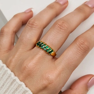 Close-up of 18K gold plated ring with a row of green rectangular zircon stones