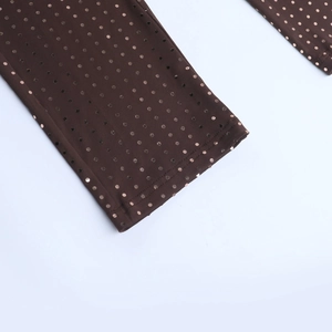 Detailed macro view of dark brown elastic fabric with shimmering rose gold sequins