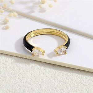 Macro detail of 18K gold plated ring with black enamel and pear-cut cubic zirconia