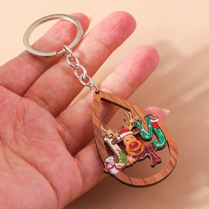 Gros plan d'un porte-clés de Noël en bois en forme de goutte avec motif renne
