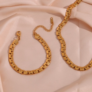 Detail of 18K gold-plated 6.2mm flat square chain necklace and bracelet on pink silk