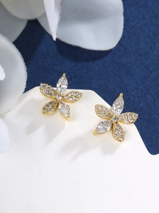 Macro shot of gold-plated flower stud earrings with marquise and pavé zircon stones