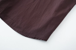 Close-up of the curved hem stitching on this dark brown cotton poplin shirt