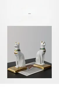 Detail of white Bastet cat statues with blue gold collars and hieroglyphic golden bases