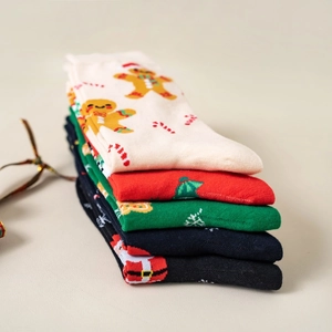 Five pairs of festive Christmas mid-tube socks featuring Santa and gingerbread motifs