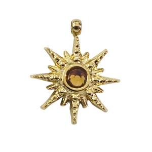 Detail of 14k gold star pendant featuring a centered amber zircon with textured finish