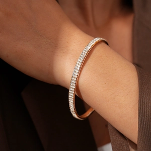 Macro shot of a luxury rose gold bracelet with three rows of pavé diamonds on a wrist