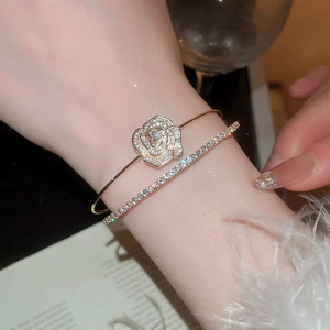 Detail of elegant gold double-layered rose and zircon bracelet on woman's wrist