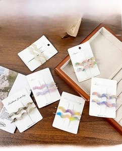 Six sets of colorful acetate wavy hair clips displayed on elegant white paper cards