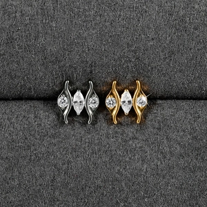 Detailed macro view of heart-shaped labret jewelry in silver and gold with zircon stones