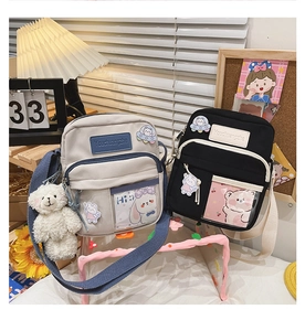 Détail de sacs bandoulière en toile avec breloques d'ours et écussons mignons