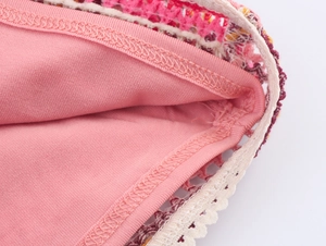 Close-up of pink crochet knit polo shirt with detailed stitching and lace texture