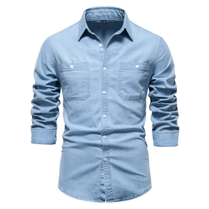 Detailed view of light blue denim shirt with double chest pockets and classic stitching