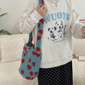 Blue plush shoulder bag with red heart pattern paired with a casual leopard print outfit