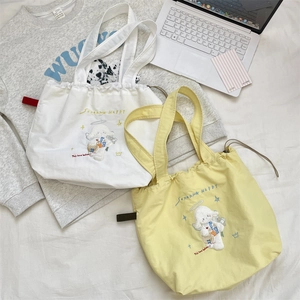 Detail of canvas bucket bags with cute dog embroidery and drawstring closure