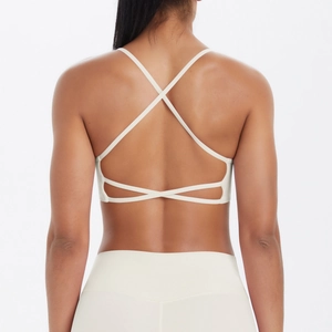 Détail du soutien-gorge de yoga à dos croisé avec plusieurs brides en tissu blanc crème