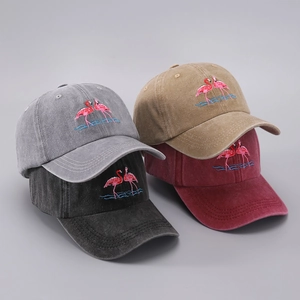 Detail of stacked washed cotton baseball caps with flamingo embroidery in multiple colors