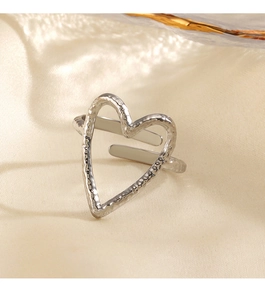 Close-up of hammered silver heart ring with adjustable band on silk background