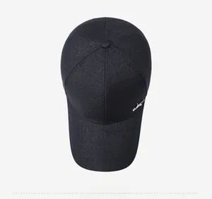 Close-up of navy baseball cap with textured fabric and metallic logo detail