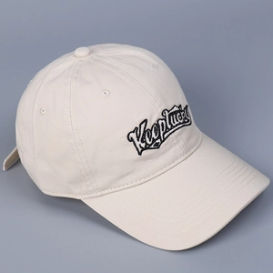 Detail shot of embroidered Keeplucky logo on beige cotton baseball cap surface