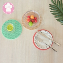 Close-up of heat-resistant silicone honeycomb table mats in three patterns on wood