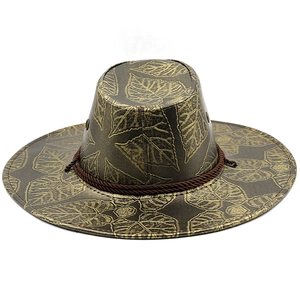 Detailansicht eines braunen Cowboyhuts mit goldenem Blattdruck und geflochtenem Band