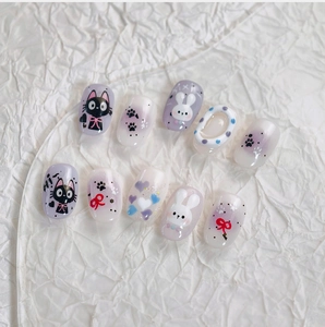 Detailed view of lavender and cream press-on nails featuring cute black cat and rabbit art