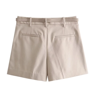 Détail de l'arrière d'un short beige avec poches passepoilées et ceinture assortie