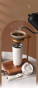 Close-up of a white wide-mouth coffee tumbler being filled with hand-poured coffee