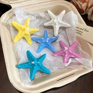 Detailed view of colorful resin starfish hair clips in white, pink, and blue shades