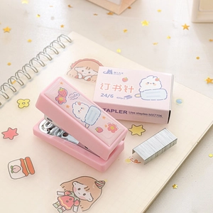 Mini cucitrice rosa portatile con punti 24/6 su un taccuino decorativo in stile