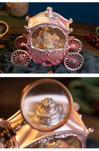 Macro shot of silver crown on pink princess carriage music box with blue dress figurine
