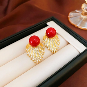 Detail of leaf fan earrings with red pearl and pavé crystals in luxury jewelry box