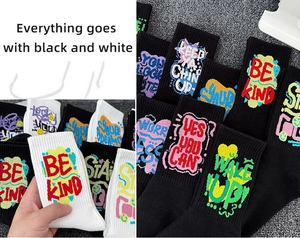 Detail showing assorted black and white crew socks with motivational slogan graffiti patterns
