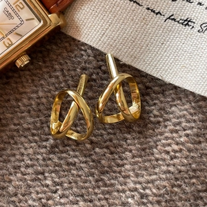 Minimalist 925 silver golden knot earrings on warm knitted background
