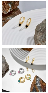 Detail of gold and silver heart earrings with colorful enamel and diamond accents