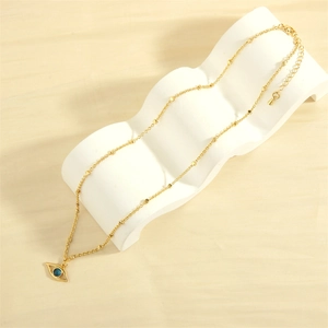 Detailed close-up of 18K gold plated evil eye pendant with blue crystal on a link chain