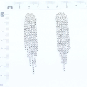 Detailed size measurement of silver tassel earrings with crystal rhinestones on scale