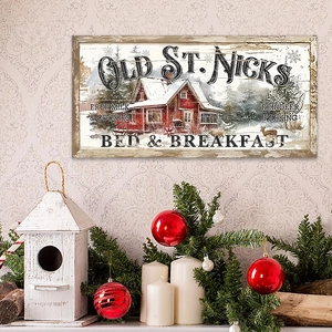 Close-up of Old St. Nicks wooden Christmas sign with snowy red cabin and retro art text