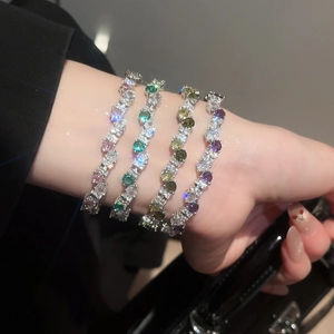 Macro view of colorful zircon gemstone bracelets on a dark suit and leather bag