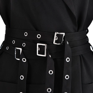 Detailed macro view of the waist belts with silver eyelets and square metal buckles on the blazer