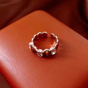 Detail of vintage silver open ring featuring brown tiger eye stone and small white gems